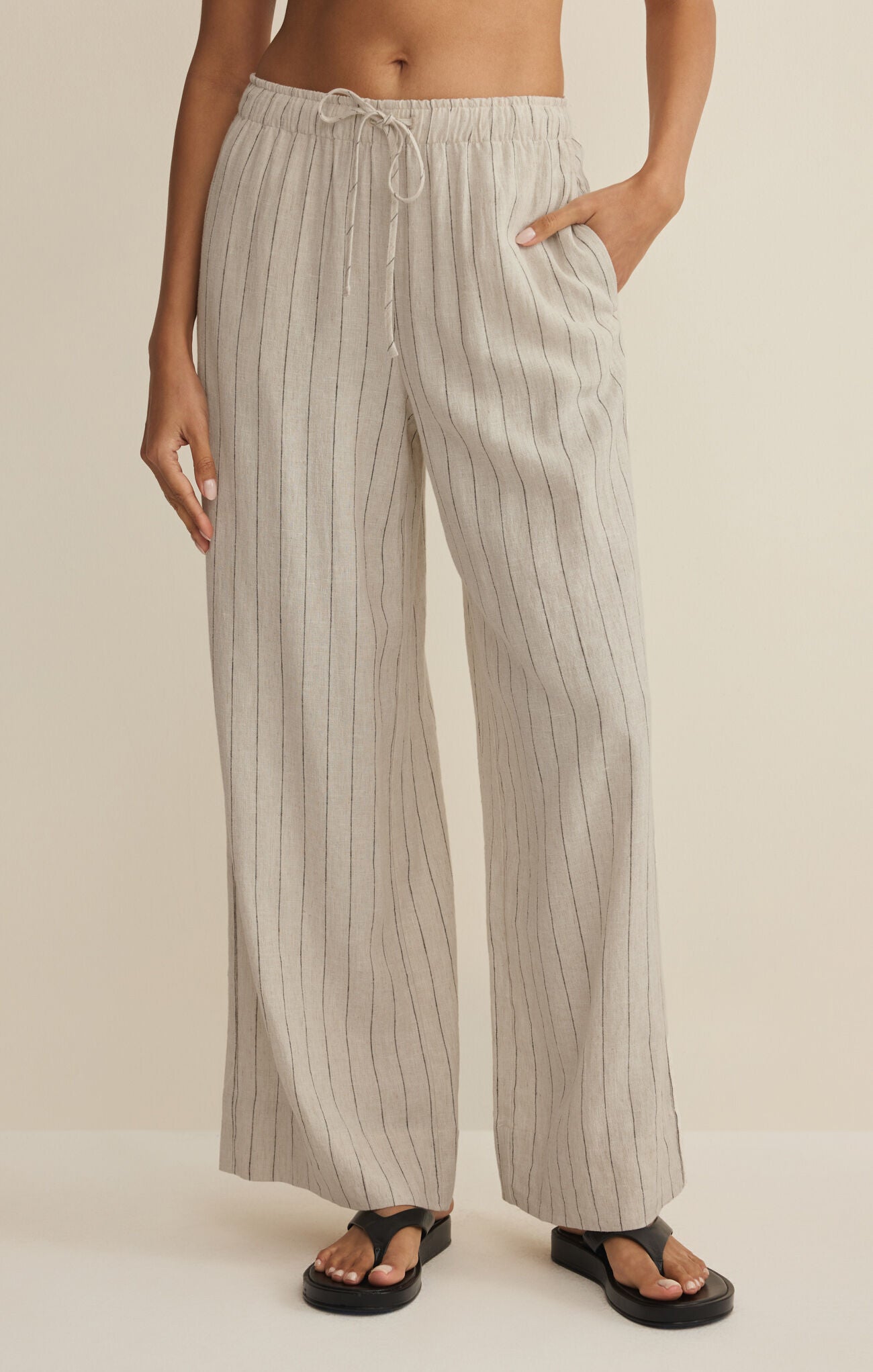 Striped pants worn by a person on a beige background