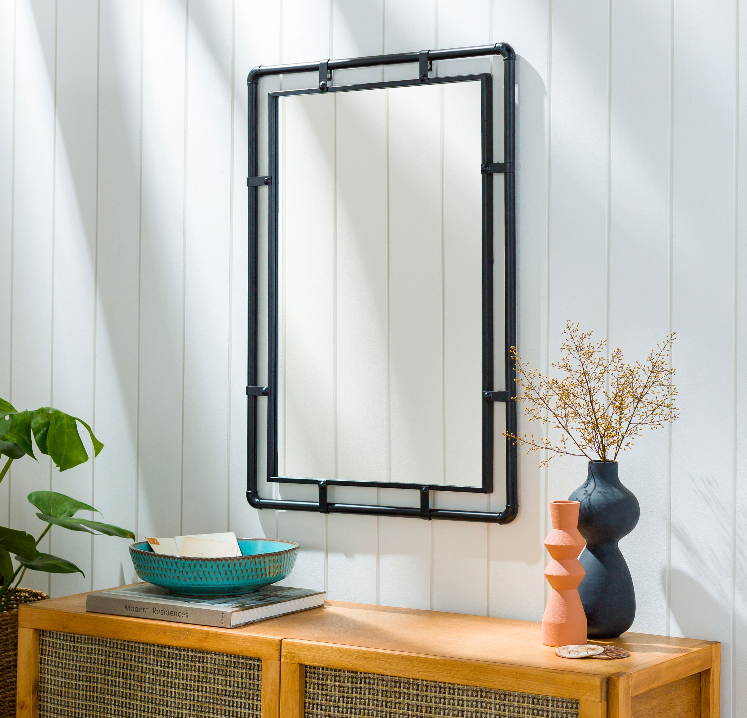 Indus Accent Mirror on a white wall above a table at Addison West