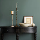 Woodbridge Furniture Salutation Demilune Table in Worn Black Finish on a green background at Addison West