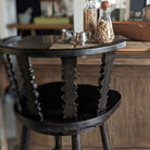 Fable Bar Stool in Worn Black Finish at a table at Addison West