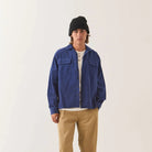 Male model wearing Brixton Men's Century Overshirt in Blue & Navy Shadow on plain background.