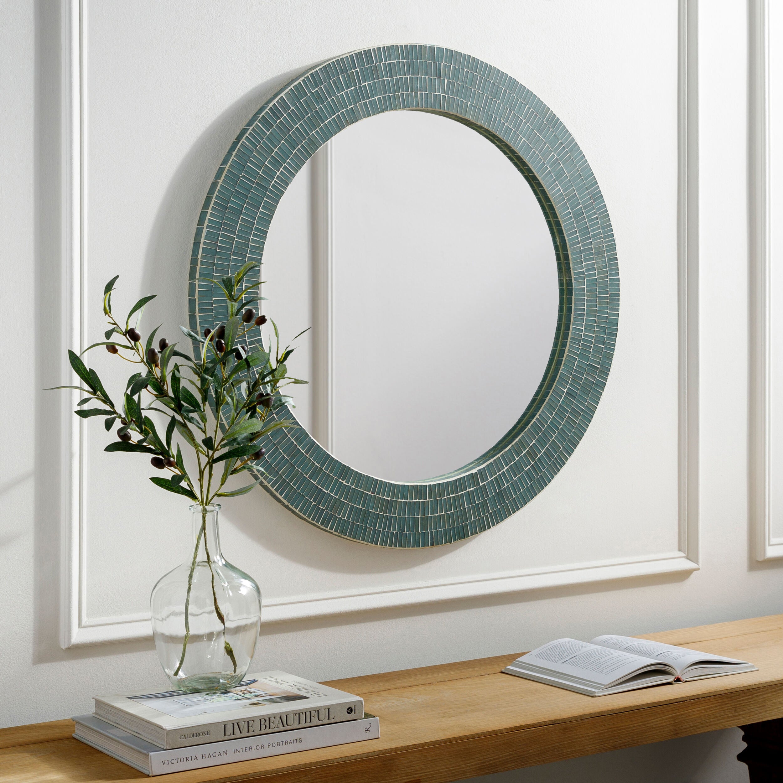 Natalia Accent Mirror on a white wall above at table at Addison West