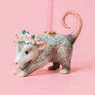Decorative possum cake topper with a crown on a pink background