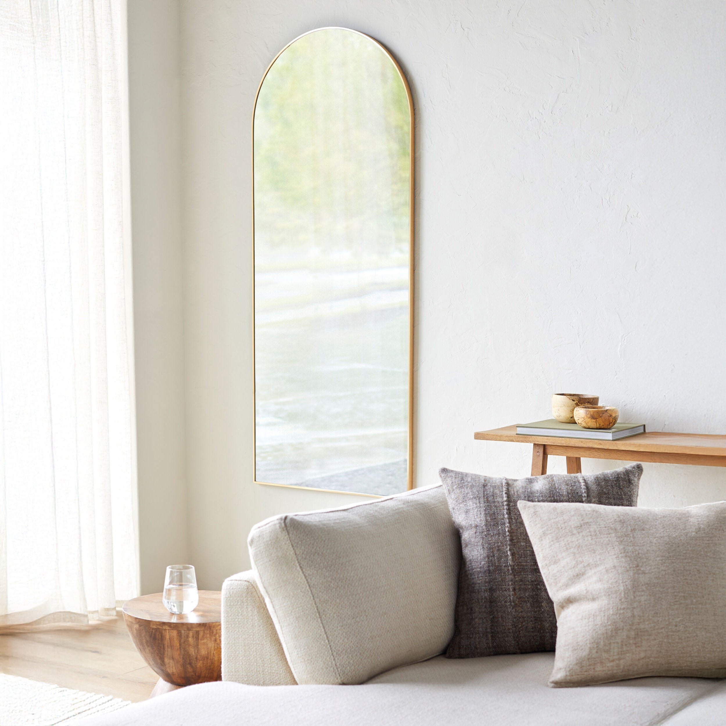 Aranya Arch Full Length Mirror on a white wall in a living room at Addison West