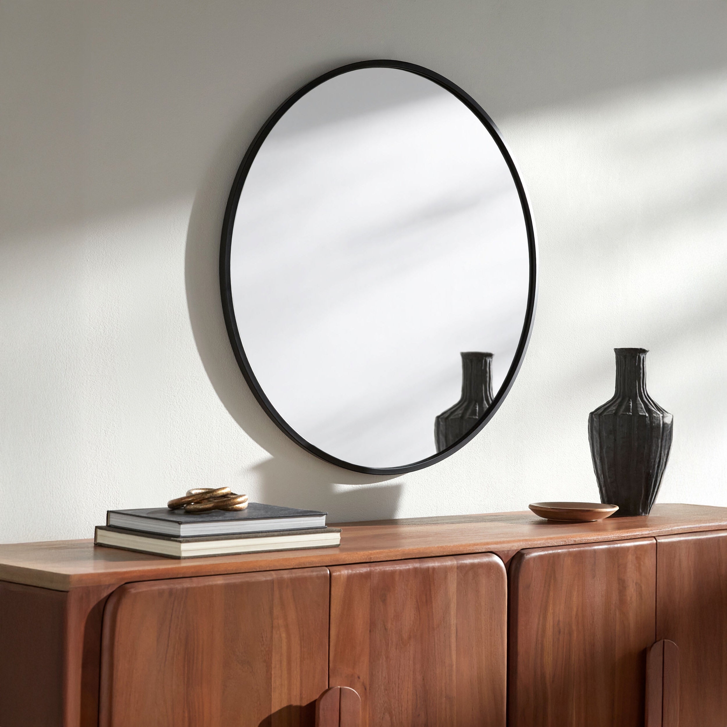 Carmen Accent Mirror on a white wall above a table  at Addison West 