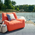 Clover Stripe 20" Square Indoor/Outdoor Pillow in Navy on an orange chair on a dock at Addison West