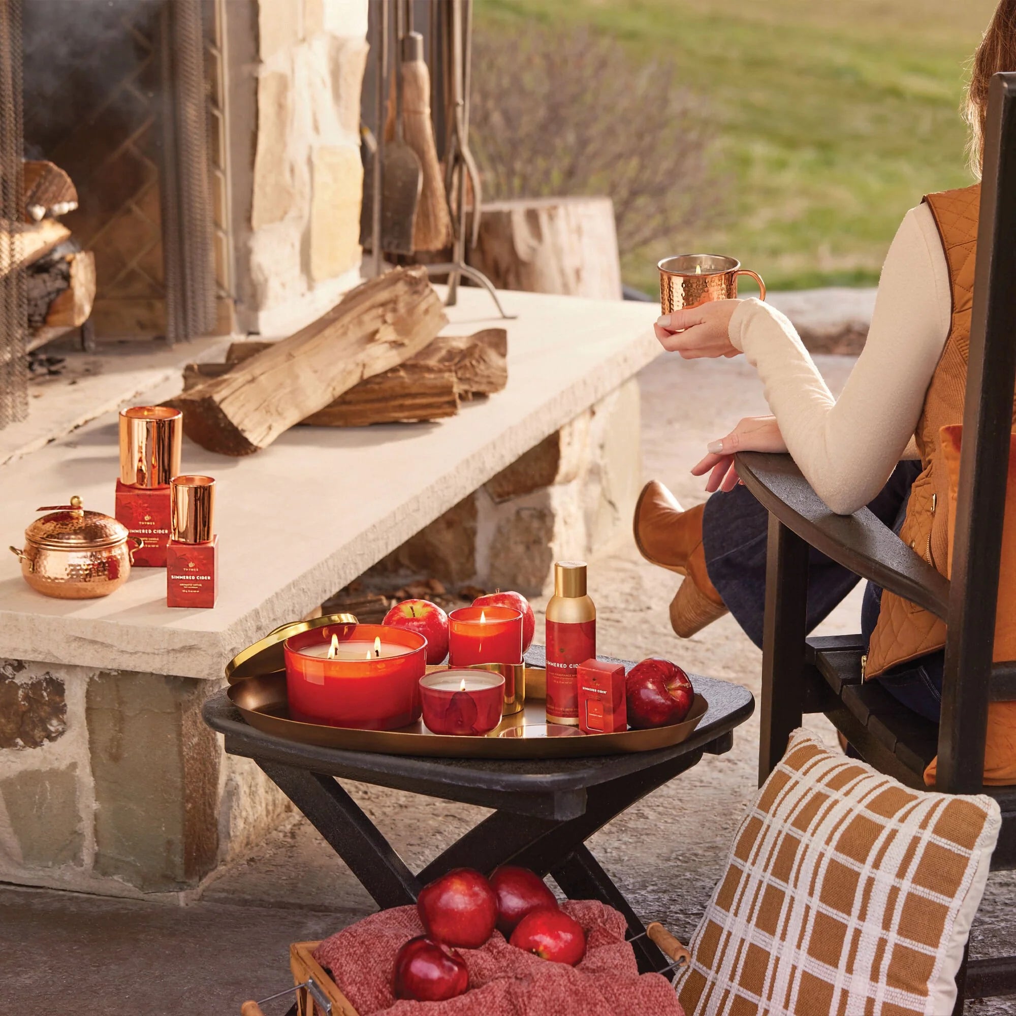 Thymes Simmered Cider Votive Candle on an outdoor fireplace at Addison West