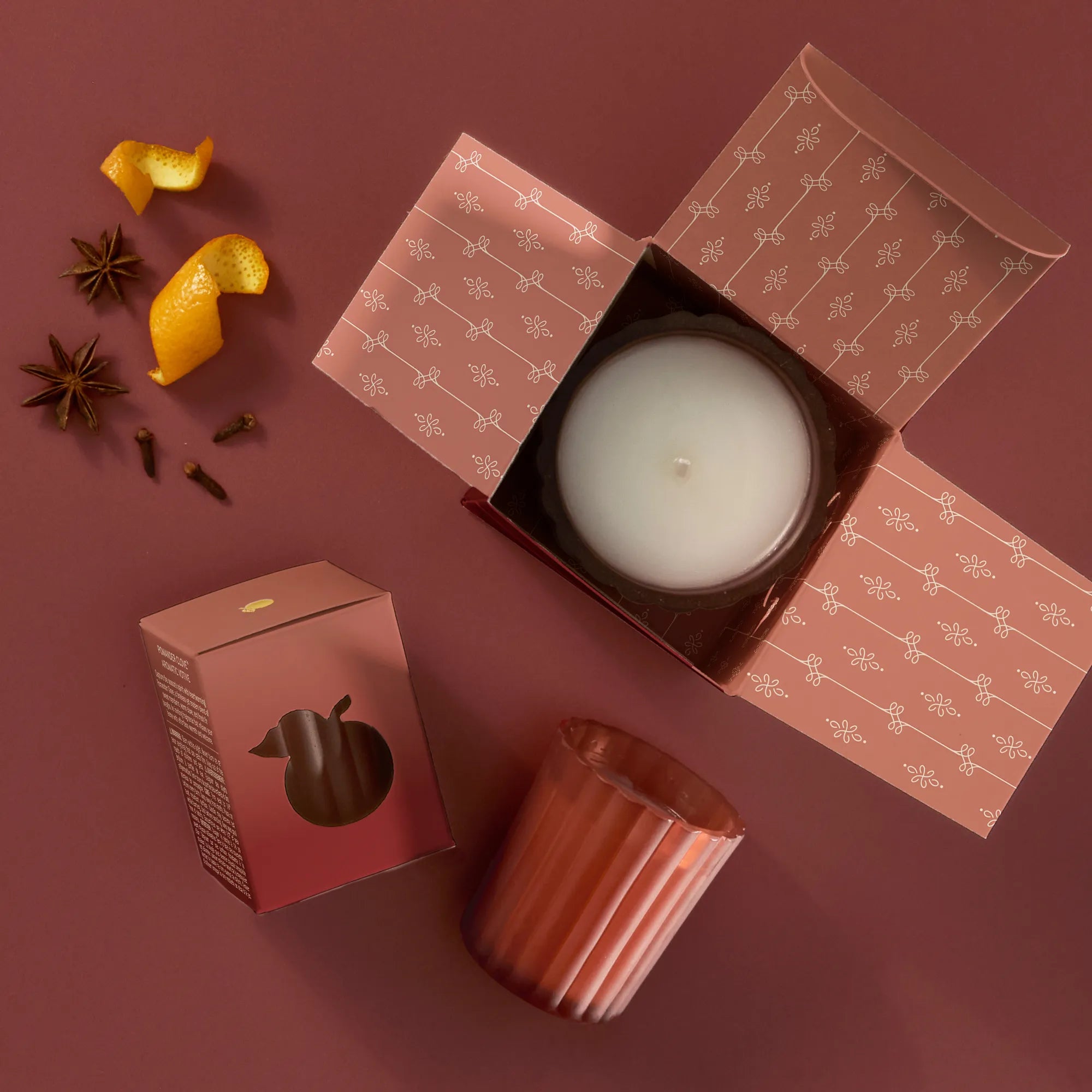 Thymes Pomander Clove Candle 6.1 oz on a red background at Addison West