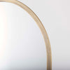 Arched top wall mirror with brushed gold finish on a white background