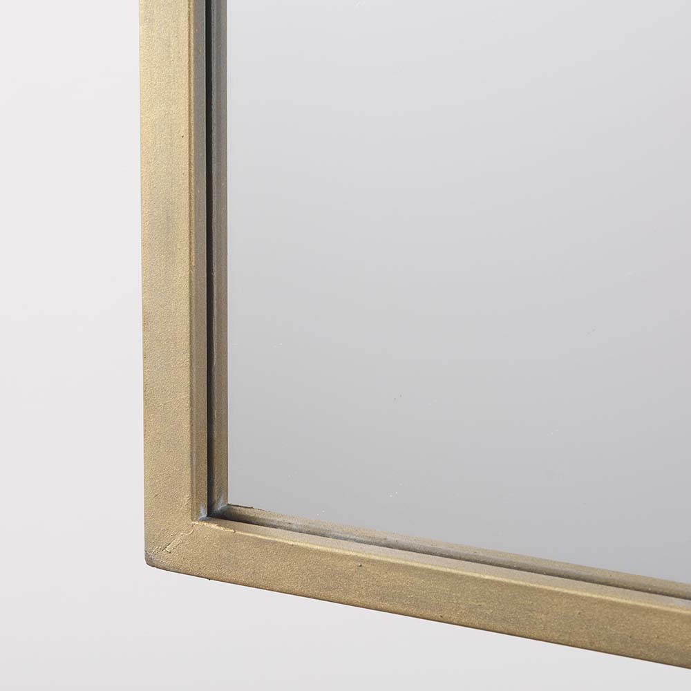 Arched top wall mirror with brushed gold finish on a white background