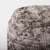Close up of Grey square pouf with cotton and leather accents in geometric pattern on a white background