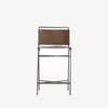 Four hands brand wharton counter stool with black iron frame and dark brown leather seat on a white background