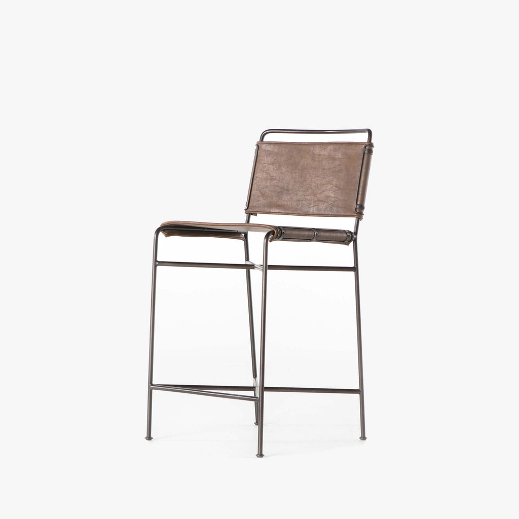 Four hands brand wharton counter stool with black iron frame and dark brown leather seat on a white background