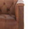 Close up of nail heads on Four hands brand Maxx squared arm Chesterfield style swivel chair in brown leather with nail heads on a white background