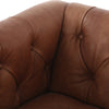 Close up of leather on Four hands brand Maxx squared arm Chesterfield style swivel chair in brown leather with nail heads on a white background