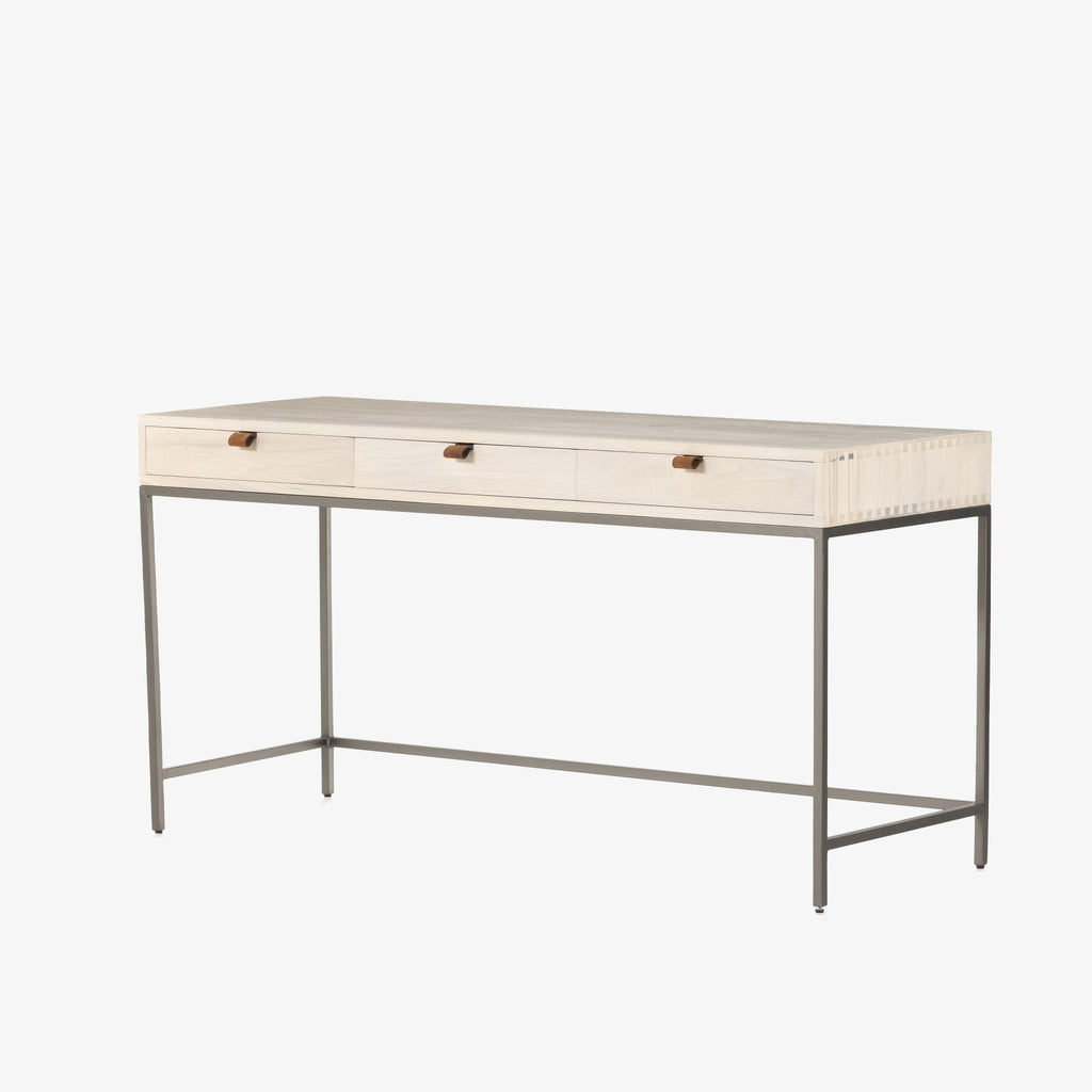 Four hands brand Trey Modular writing desk with whitewashed wood and three drawers with leather pulls and iron base on a white background
