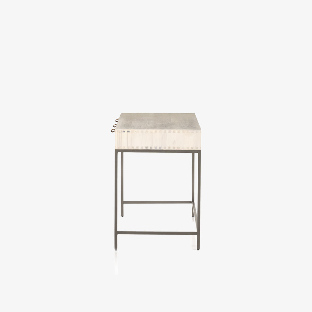 Side view of Four hands brand Trey Modular writing desk with whitewashed wood and three drawers with leather pulls and iron base on a white background