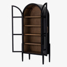 Four hands furniture brand Tolle black cabinet with arched top and wood stained interior and two glass doors on a white background  