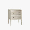 Aged white side table with two drawers and star shaped pulls on a white background