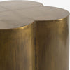 Close up of brass cladding on clover shaped side table on a white background