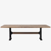 Large rectangular wood dining table with trestle style iron base on a white background