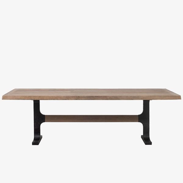 Large rectangular wood dining table with trestle style iron base on a white background