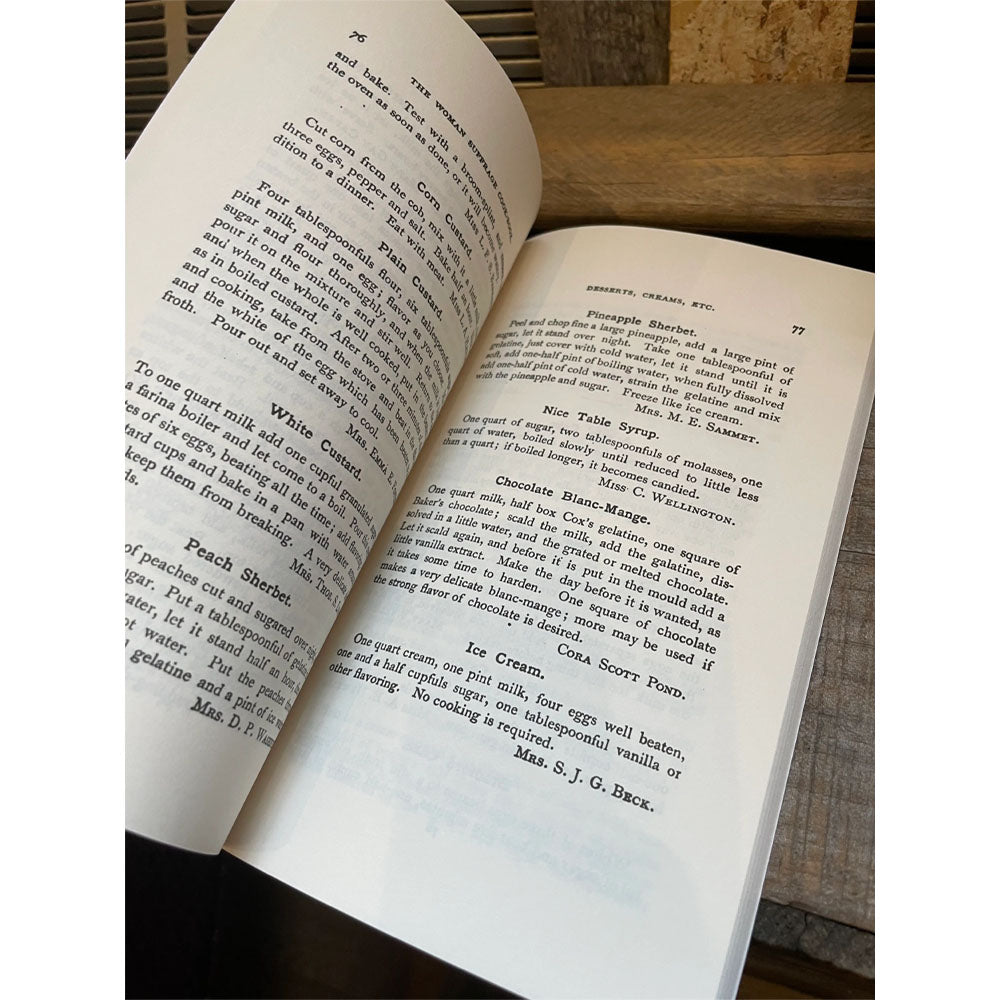 Inside pages of book titled 'The woman suffrage cook book' on a white background