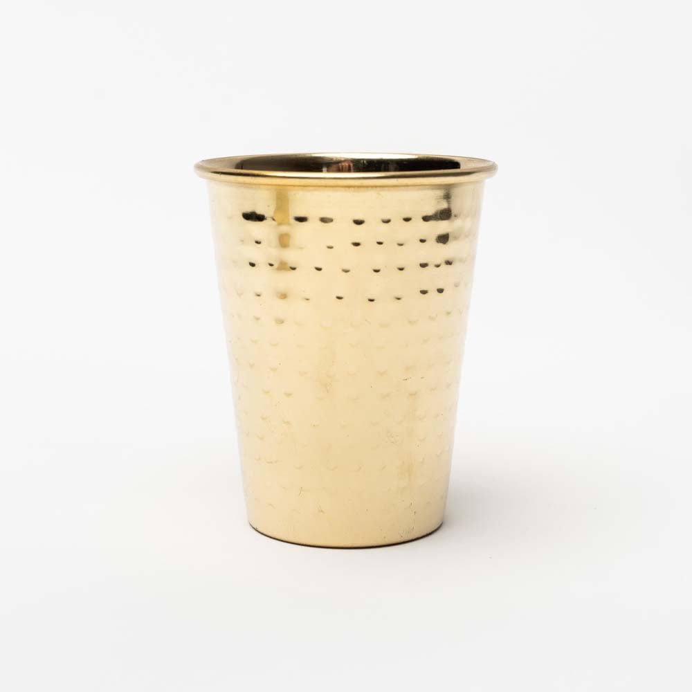 Metal drinking cup with hammered brass finish on a white background