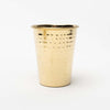Metal drinking cup with hammered brass finish on a white background
