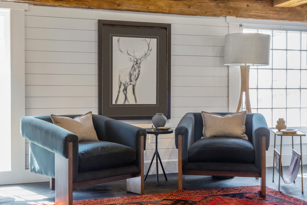 Pair of dark blue velvet 'Cairo' chairs by four hands furniture brand in a living space with white wall and lamp and windows