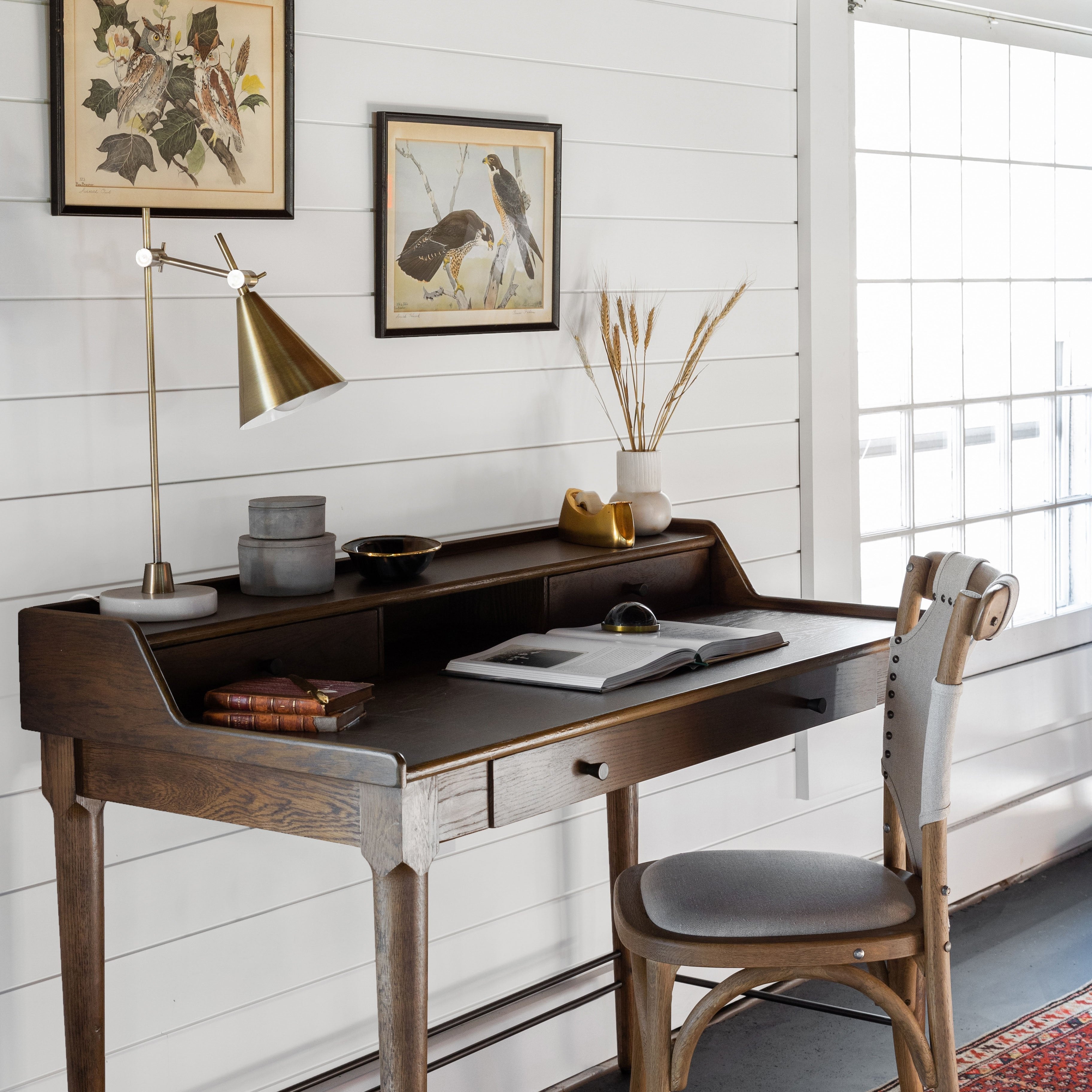 Wood desk with chair and lamp and desk accessories including two cement boxes stacked 