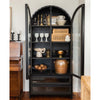 Mercana steel and glass arch top cabinet in a room with a wood floor
