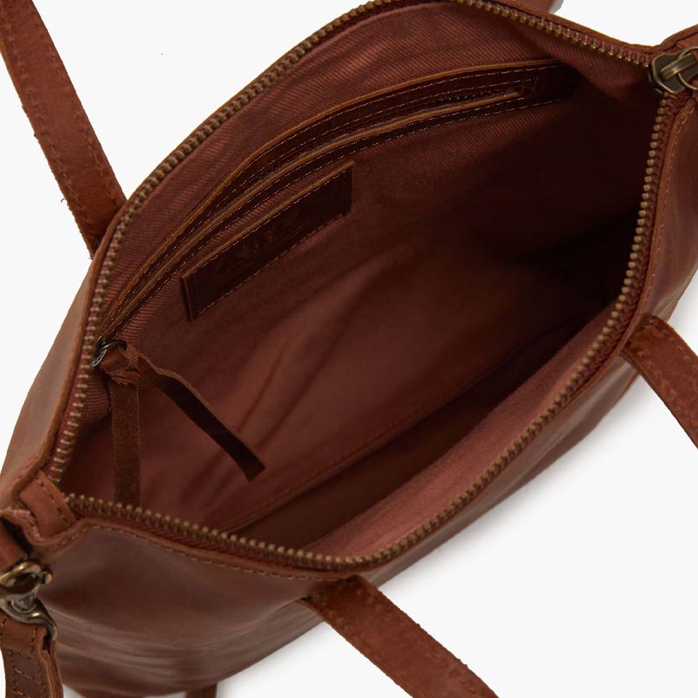 Interior view of Able brand Abera Commuter bag in whiskey leather on a white background.