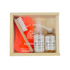 Sneaker care kit with soap and brush and sponge in a wood box with acrylic lid on a white background