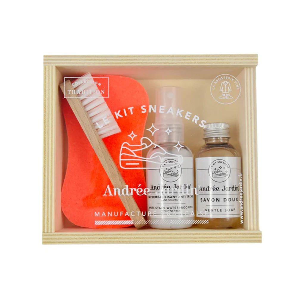 Sneaker care kit with soap and brush and sponge in a wood box with acrylic lid on a white background