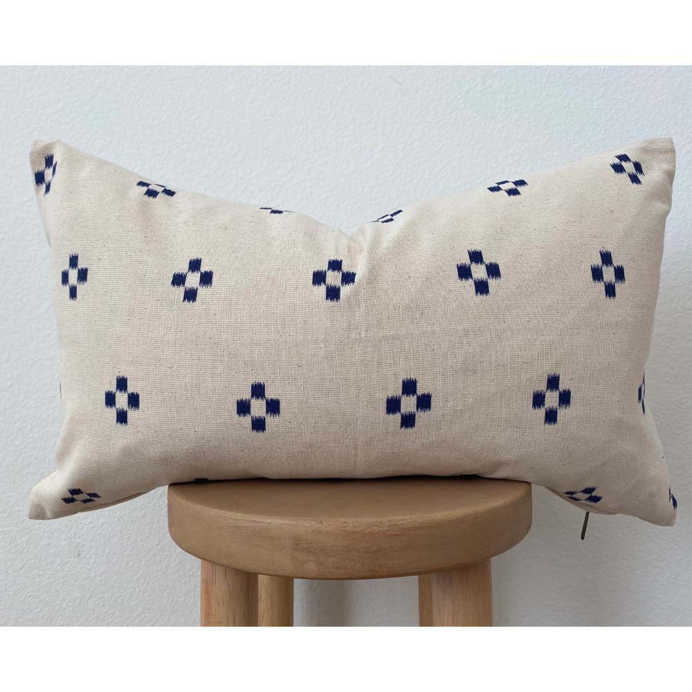 Lumbar pillow with natural background and midnight blue diamond pattern on a still in front of a white backdrop