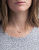 Brunette model wearing Able brand 14k gold filled arch necklace