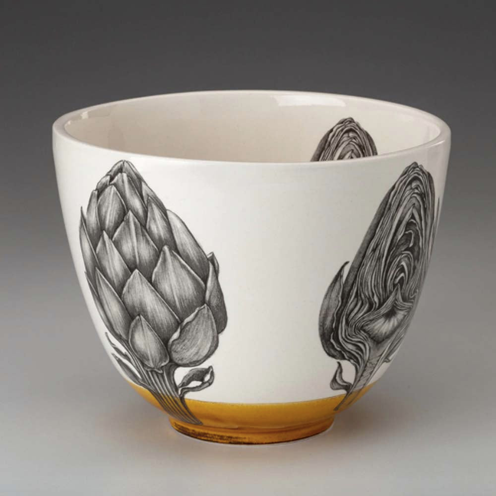 Laura Zindel artichoke bowl with amber glaze accent on a grey background 