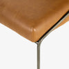 Close up of Four Hands Brand Astrud dining chair with brown leather seat and back and iron legs on a white background