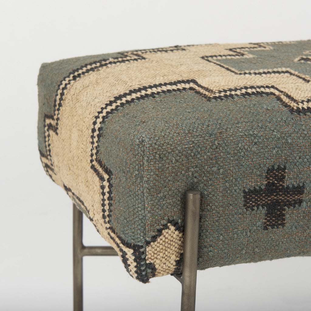 Close up of fabric on bench with patterned wool seat cover in muted charcoal green and cream on a