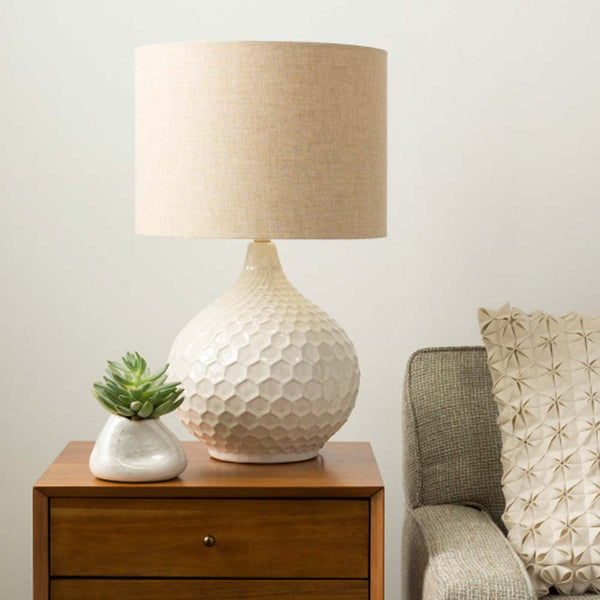 Surya Blakey table lamp with round white base and linen shade on a wood side table
