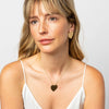 Model wearing Necklace with brass heart pendant on a white background