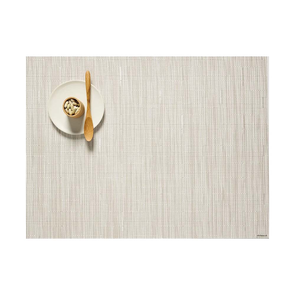 Chilewich Bamboo Signature Rectangle Placemat in coconut on a white background with a small plate and wood spoon