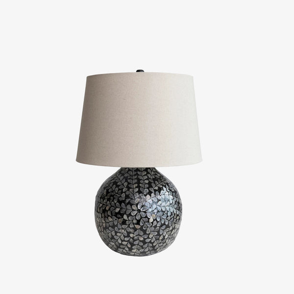 Bamboo and mother of pearl table lamp with linen shade on a white background