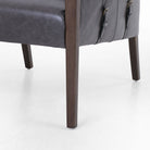 Four Hands Furniture brand Bauer chair in chaps ebony with stained wood legs and leather buckled straps on a white background