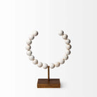 Mercana beaded broken sphere object in white with gold base on white background