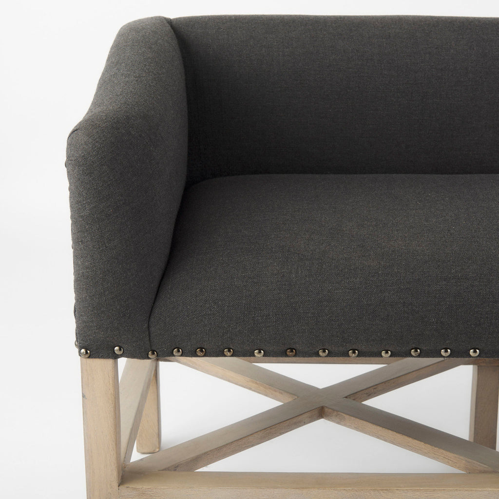 Grey upholstered accent bench with trellis wood base and small bolster back and nail head finish
