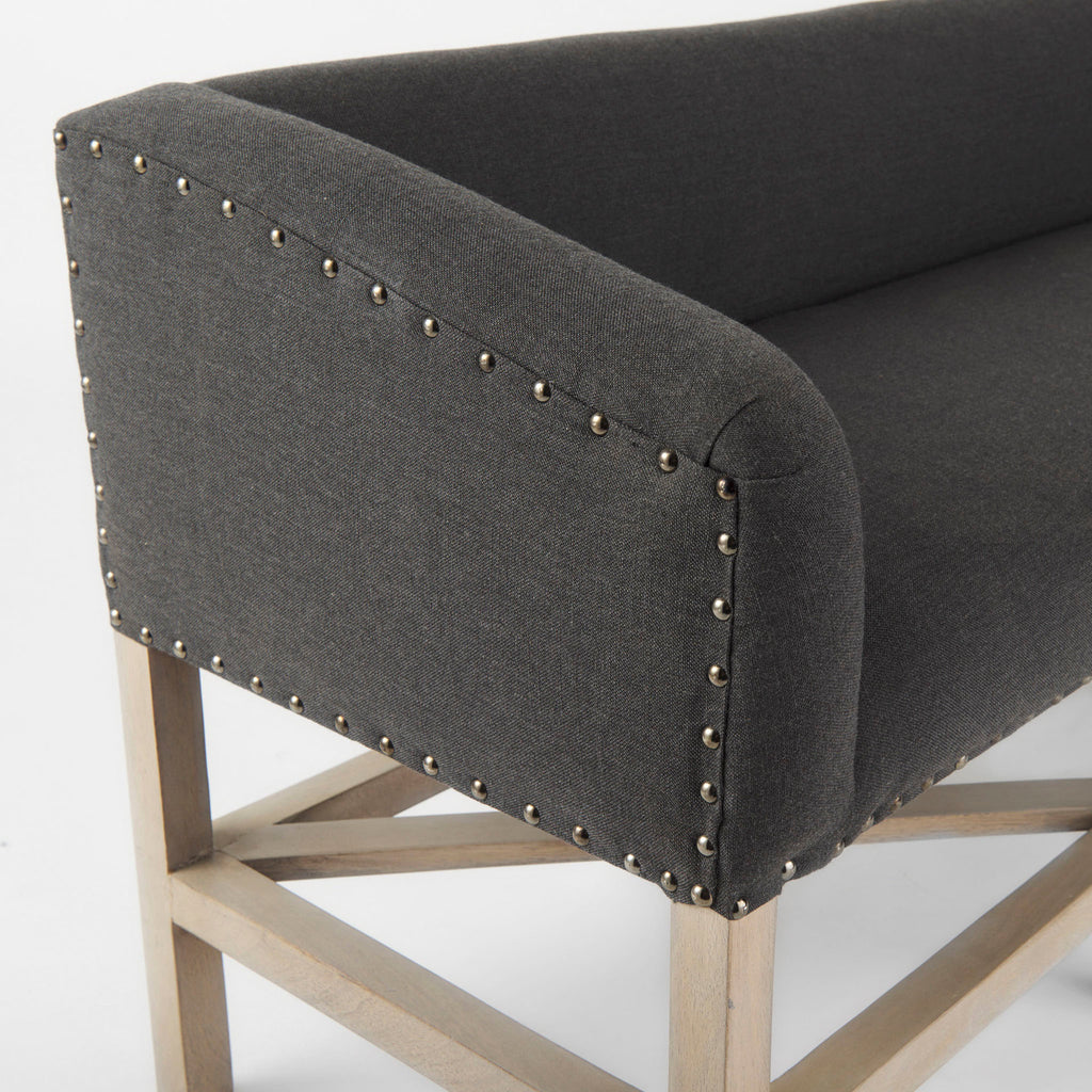Grey upholstered accent bench with trellis wood base and small bolster back and nail head finish
