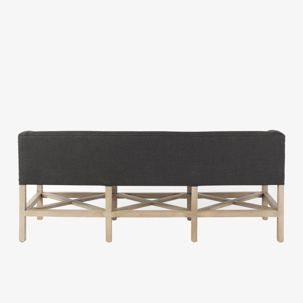 Grey upholstered accent bench with trellis wood base and small bolster back and nail head finish