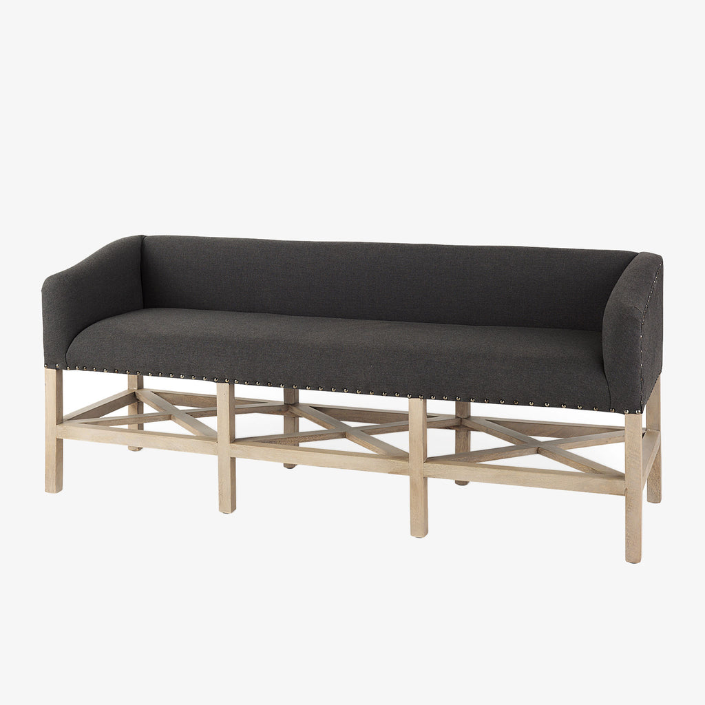 Grey upholstered accent bench with trellis wood base and small bolster back and nail head finish